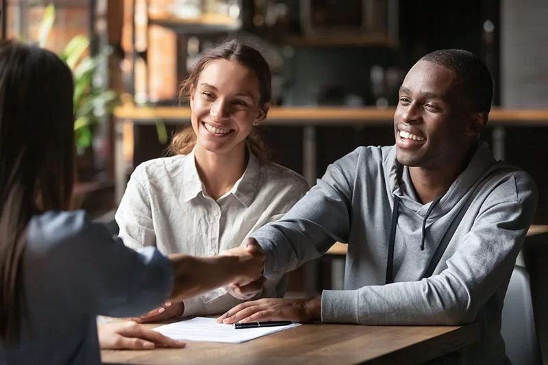 A couple working with a VA loan broker to qualify for a loan.