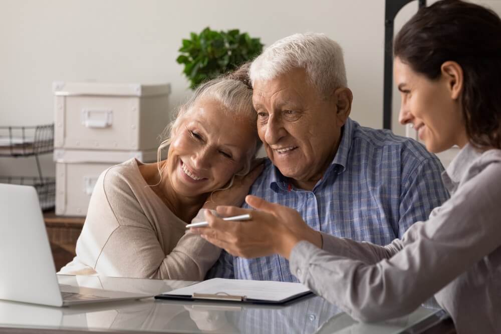 A smiling older couple confirming their second deed of trust loan with a mortgage broker